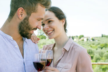 Young couple holding wine glasses face to face smiling - CUF29681