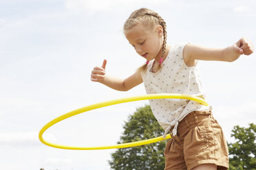 Niedriger Blickwinkel eines Mädchens, das einen Hula-Hoop-Reifen benutzt, die Arme nach unten gerichtet - CUF29685