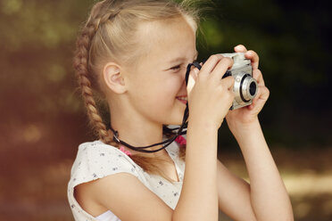 Head and shoulder side view of girl using film camera - CUF29690