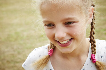 Close up portrait of girl with pigtails looking away smiling - CUF29695