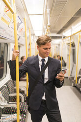 Geschäftsmann schreibt eine SMS in der U-Bahn, London Underground, UK - CUF29749