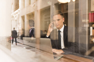 Businessman working on laptop in cafe - CUF29765