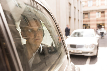 Geschäftsmann schaut aus einem schwarzen Taxi, London, UK - CUF29770