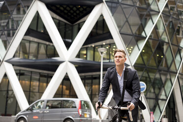 Geschäftsmann auf Fahrrad, 30 St Mary Axe im Hintergrund, London, UK - CUF29773