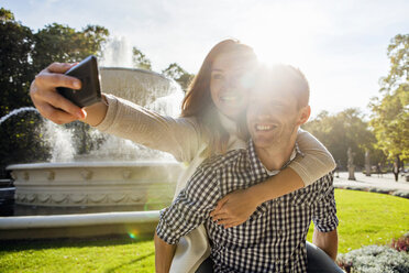Frau nimmt Selfie mit Huckepack im Park - CUF29825