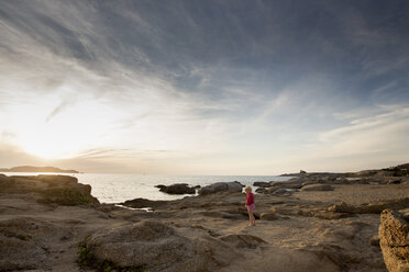 Female toddler on coastal rock at sunset, Calvi, Corsica, France - CUF29834