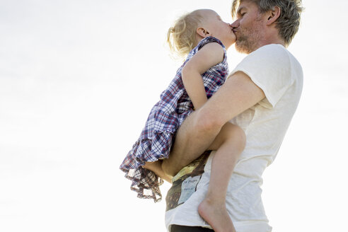 Seitenansicht eines weiblichen Kleinkindes und eines Vaters, die sich küssen - CUF29844