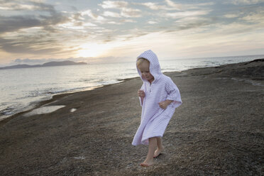 Female toddler wearing hooded robe on beach, Calvi, Corsica, France - CUF29849