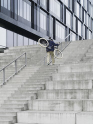 Stadtradler mit Fahrrad auf einer Treppe - CUF29975