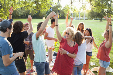 Eine Gruppe von erwachsenen Freunden tanzt auf einer Party im Park bei Sonnenuntergang - CUF30005