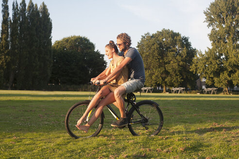 Romantisches junges Paar auf dem Fahrrad zusammen im Park - CUF30032