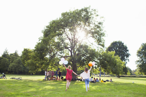 Rückansicht von zwei jungen Frauen, die mit Luftballons auf einer Parkparty tanzen - CUF30046