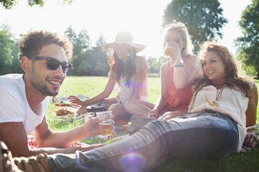 Mann und Frauen trinken und entspannen sich auf einer Parkparty - CUF30052