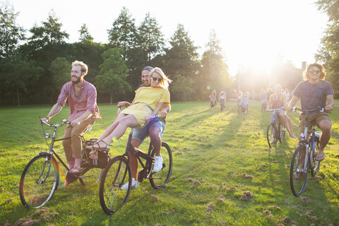 Eine Schar feierwütiger Erwachsener, die auf Fahrrädern zur Sunset Park Party anreisen, lizenzfreies Stockfoto