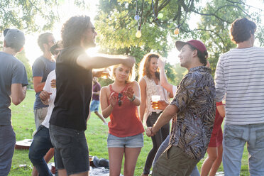 Adult friends dancing at park party at sunset - CUF30079