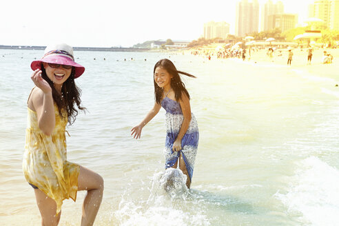 Mädchen und Mutter beim Planschen im Meer, Zhuhai, Guangdong, China - CUF30235