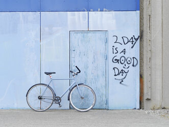 Bicycle parked against graffiti wall - CUF30290