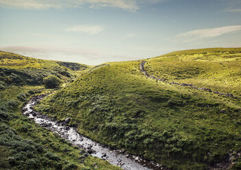 Fluss, der durch eine hügelige Landschaft fließt, Brecon Beacons, Wales, UK - CUF30297