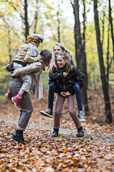Mutter und Töchter spielen Huckepack im Herbstwald - CUF30522