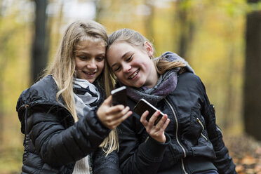 Mädchen benutzen Smartphone im Herbstwald - CUF30527