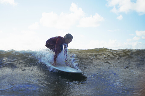 Männlicher Surfer auf einer Welle, lizenzfreies Stockfoto