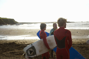 Gruppe von Surfern steht am Strand, hält Surfbretter, Rückansicht - CUF30656