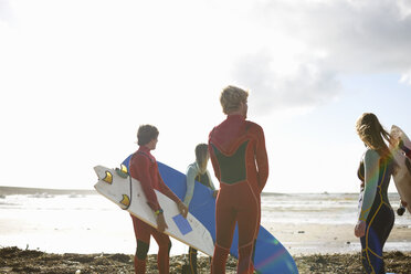 Gruppe von Surfern steht am Strand, hält Surfbretter, Rückansicht - CUF30657