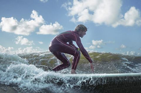 Männlicher Surfer auf einer Welle, lizenzfreies Stockfoto