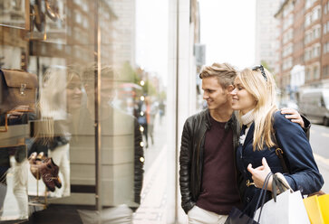 Young couple window shopping, London, England, UK - CUF30776