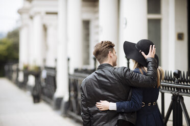 Rückansicht eines romantischen jungen Paares, das auf der Straße spazieren geht, London, England, UK - CUF30786