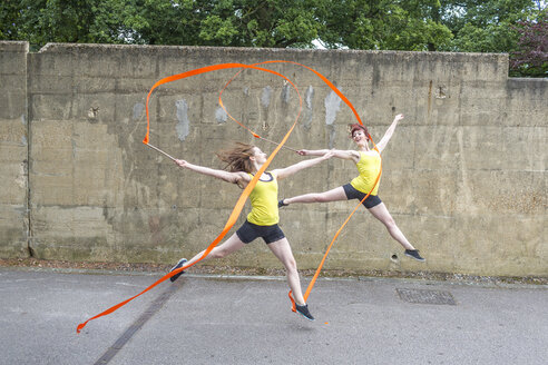 Young women practising ribbon dance on court - CUF30873