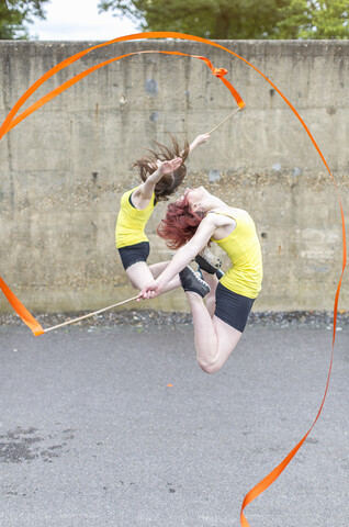 Young women practising ribbon dance on court stock photo