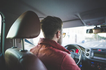 Rear view of young man on the road driving car - CUF31146