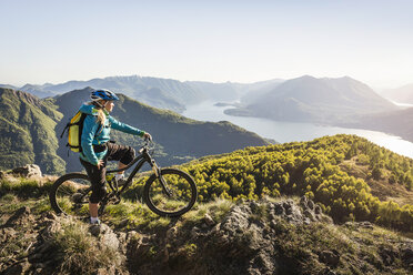 Junge Frau auf Mountainbike, mit Blick auf die Aussicht, Comer See, Italien - CUF31164