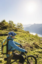 Junge Frau auf Mountainbike, mit Blick auf die Aussicht, Comer See, Italien - CUF31165