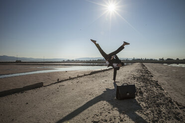 Mittlerer Erwachsener Geschäftsmann macht Handstand am Strand - CUF31175