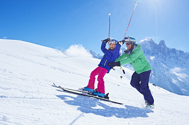 Father guiding daughter to ski, Chamonix, France - CUF31234