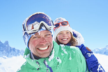 Father giving daughter piggyback ride, Chamonix, France - CUF31261