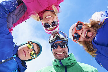 Niedriger Blickwinkel auf eine Familie in Winterkleidung und Sonnenbrille - CUF31270