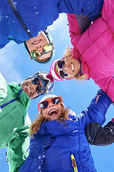 Niedriger Blickwinkel auf eine Familie in Winterkleidung und Sonnenbrille - CUF31271