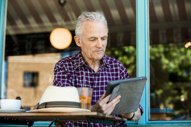 Senior man using digital tablet at cafe - CUF31282