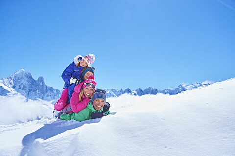 Familie spielt im Schnee, Chamonix, Frankreich, lizenzfreies Stockfoto