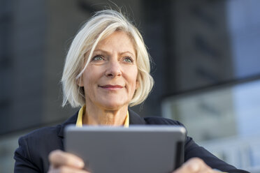 Porträt einer lächelnden älteren Geschäftsfrau mit Tablet im Freien - FMKF05139