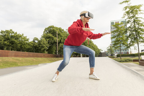 Ältere Frau mit VR-Brille im Freien, lizenzfreies Stockfoto