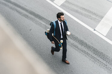 Geschäftsmann mit Kaffee zum Mitnehmen und Skateboard auf der Straße - UUF14084