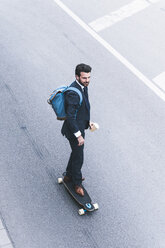 Businessman riding skateboard on the street - UUF14087