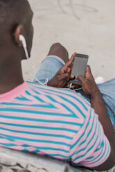 Young man in skatepark sitting on bench, listening music - ACPF00013