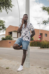 Young man in the city, standing in the street, talking on the phone - ACPF00020