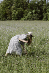 Italien, Venetien, Junge Frau pflückt Blumen und Kräuter auf einem Feld - ALBF00402