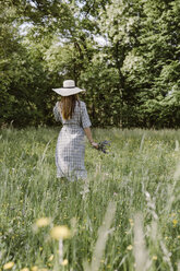 Italien, Venetien, Junge Frau pflückt Blumen und Kräuter auf einem Feld - ALBF00409